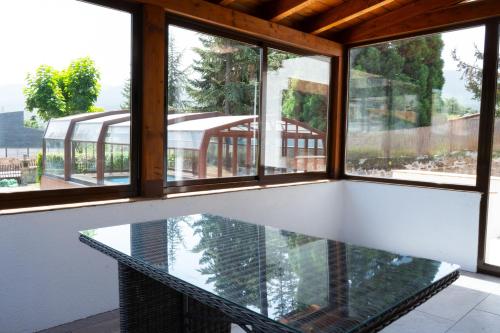 a glass table in a room with windows at UN PASEO POR LAS NUBES in El Espinar