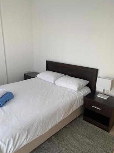 a bedroom with a bed with two nightstands and two lamps at Aphrodite Beachfront Apartment - North Cyprus in Ghaziveran
