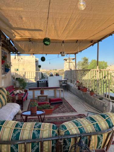 a patio with couches and tables on a roof at Darna Hostel in Amman