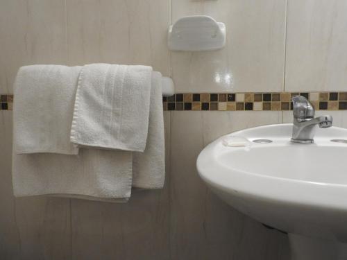 a bathroom with a sink and white towels at Hotel Ideal in Montevideo