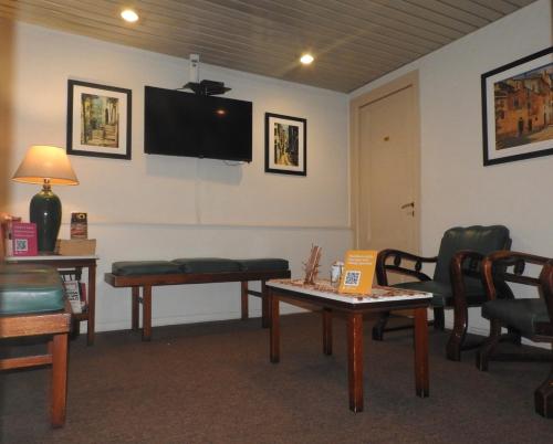 a waiting room with chairs and a tv on the wall at Hotel Ideal in Montevideo