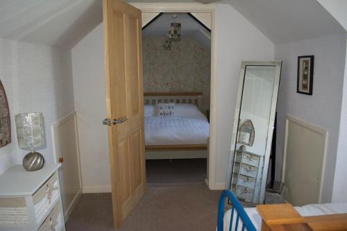 ein kleines Schlafzimmer mit einem Bett und einem Spiegel in der Unterkunft Grooms in Bude