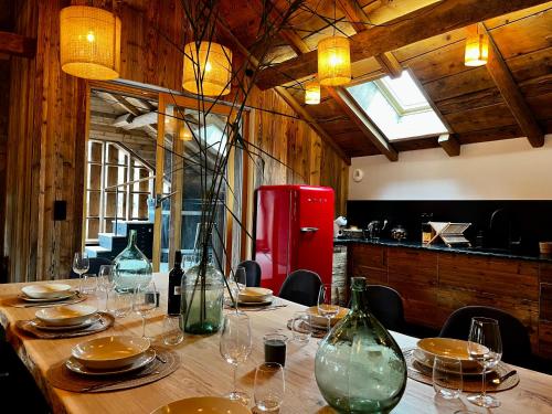 einen Tisch mit Gläsern und Tellern sowie einen roten Kühlschrank in der Unterkunft Stone Lake Luxury Lodge in Gérardmer