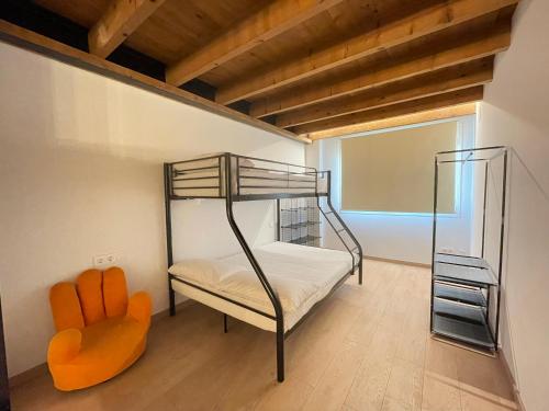 a bedroom with a bunk bed and a chair at Manresa industrial home in Manresa