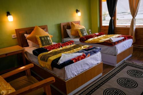 2 camas individuales en una habitación con ventana en THE RIVERSIDE RESORT Hunder en Leh