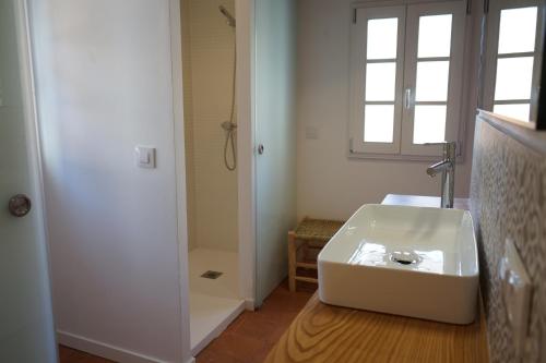 een badkamer met een witte wastafel en een douche bij Es Mirador Hotel in Ciutadella