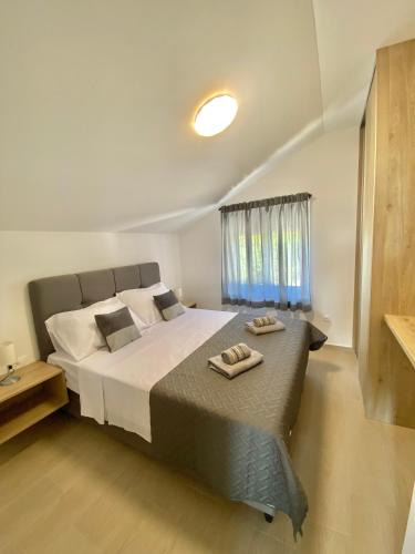 a bedroom with a large bed with two towels on it at Theros in Bibinje