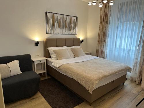1 dormitorio con 1 cama grande y 1 sofá en Luxury city rooms, en Ogulin
