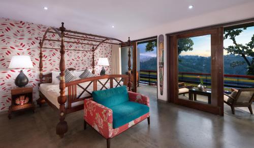 
a bedroom with a bed, chair, and table in it at The Elephant Stables in Kandy
