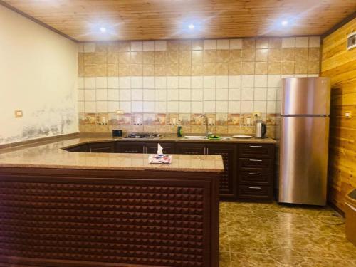 a large kitchen with a stainless steel refrigerator at North Jewel 2023 in Ajloun