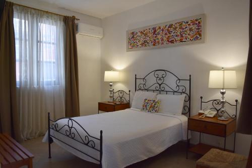 a bedroom with a bed and two lamps and a window at Ex Hacienda Santa Cecilia in Cuernavaca