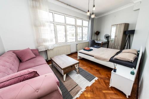 - un salon avec un canapé rose et un lit dans l'établissement fully furnished,4 bedroom ventilated apartment in kadikoy, à Istanbul