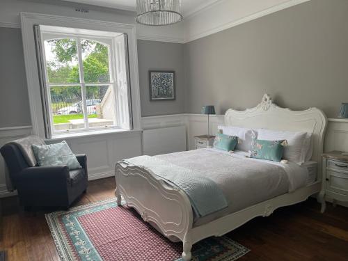 a bedroom with a bed and a chair and a window at Kenilworth Square North in Dublin