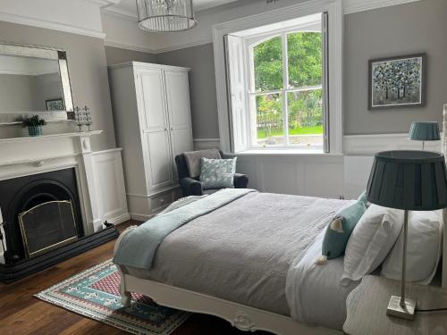 een slaapkamer met een bed en een stoel en een open haard bij Kenilworth Square North in Dublin