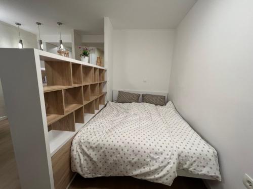 Habitación pequeña con cama y estanterías en Apartman Sara en Zenica