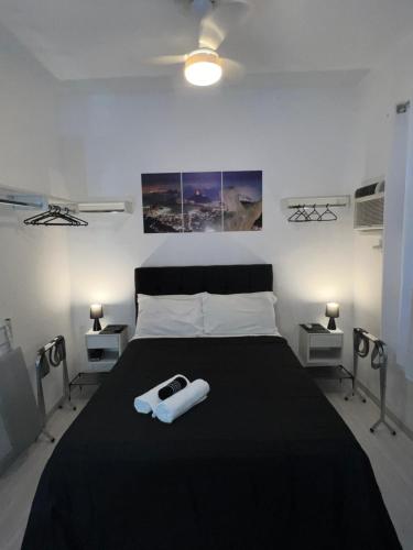 Studio Leblon في ريو دي جانيرو: غرفة نوم مع سرير كبير مع لحاف أسود
