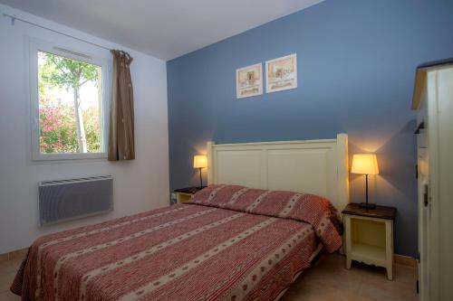ムリエスにあるRésidence Goélia Le Mas des Arènesの青いベッドルーム(ベッド1台、窓付)