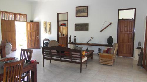 a living room with wooden doors and a table at Rumah Kita Villa/hotel in Kalibaru