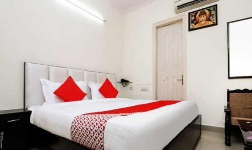 1 dormitorio con 1 cama grande con almohadas rojas en OYO Hotel Kamal, en Bharatpur