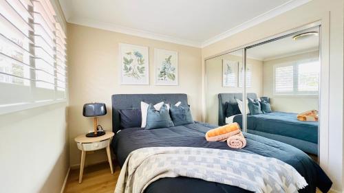 a bedroom with two blue beds and a mirror at Peaceful Sanctuary in Pennant Hills