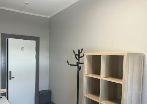 a room with a book shelf and a cross on the wall at Worker hotel ALEJPARKS in Valmiera