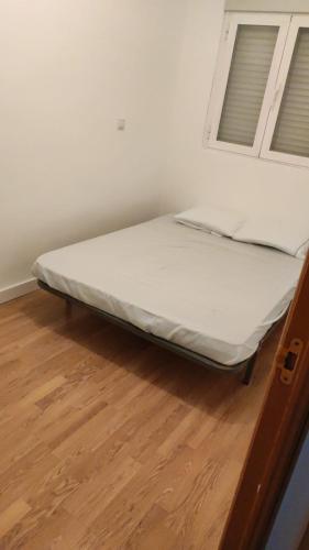 1 cama en una habitación con 2 ventanas en M&M Apartment en Madrid