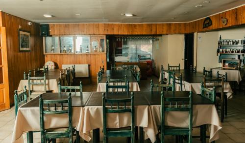 a restaurant with tables and chairs in a room at Hotel Terrazas del Lago in Puerto Varas