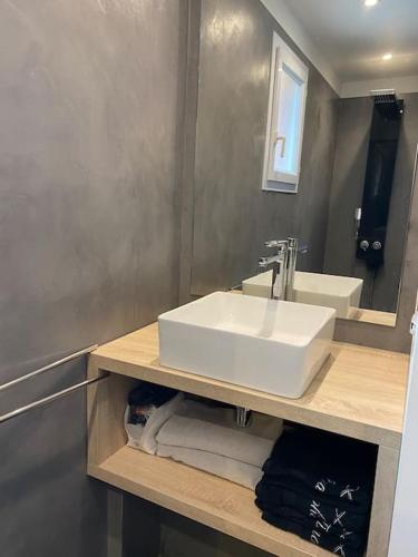 une salle de bain avec un lavabo blanc et un miroir dans l'établissement Villa Avignon Proche Rempart, à Avignon