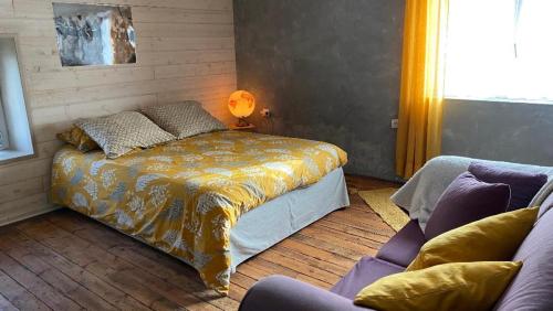 um quarto com uma cama e um sofá em Au bon endroit em Sevremont