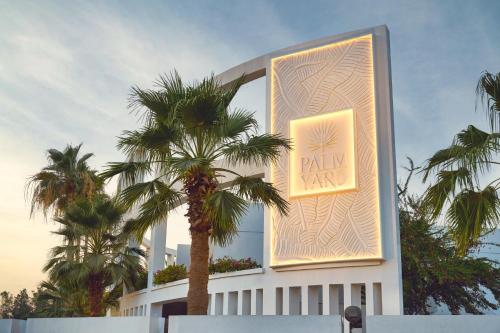 a building with a palm tree in front of it at Palmyard Hotel in Manama