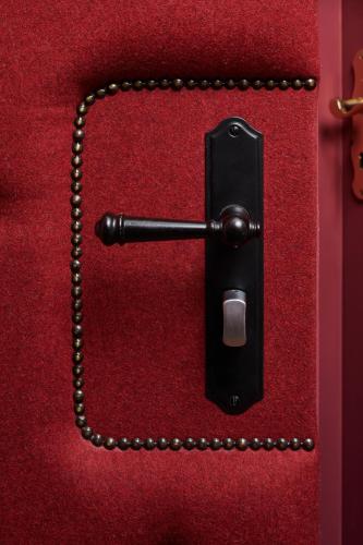 a black switch on a red wall with a chain at Hotel Der Grischäfer in Bad Emstal