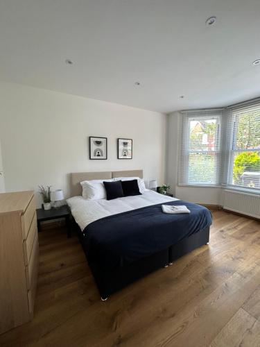 um quarto com uma cama grande e 2 janelas em Cornwall - The Duke and Duchess em Londres