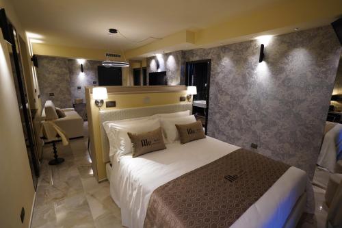 una camera da letto con un grande letto con lenzuola e cuscini bianchi di Ale Suite Sea Side View - Hotel Arizona a Riccione