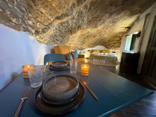 einen Tisch mit Tellern und Kerzen darüber in der Unterkunft Tajito Romano in Setenil de las Bodegas