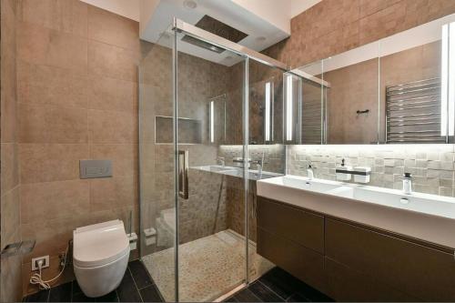 a bathroom with a shower and a toilet and a sink at Luxury rooftop appartment with fantastic views in Prague