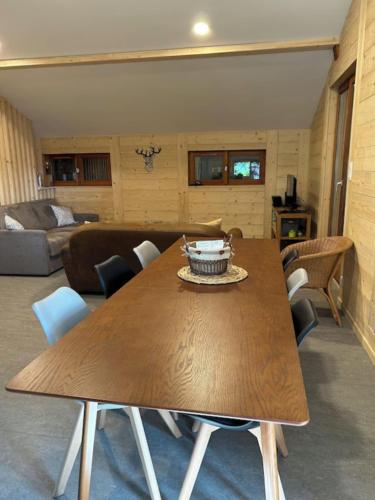 un salon avec une table et des chaises en bois dans l'établissement Chalet la parenthèse, à Le Tholy