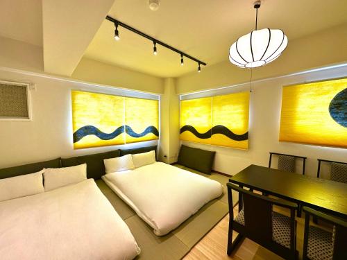 a living room with two beds and a table at 上野レトロ花 2-4人和風寝室 山手線3分 上野浅草銀座近い 御徒町駅3分 アメ横3分 上野駅10分 上野広小路駅3分 湯島駅2分 空港直接 in Tokyo
