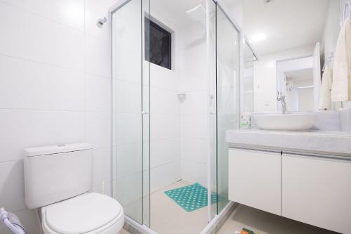 a white bathroom with a toilet and a sink at Park Del Prado #603 - Intermares por Carpediem in Cabedelo