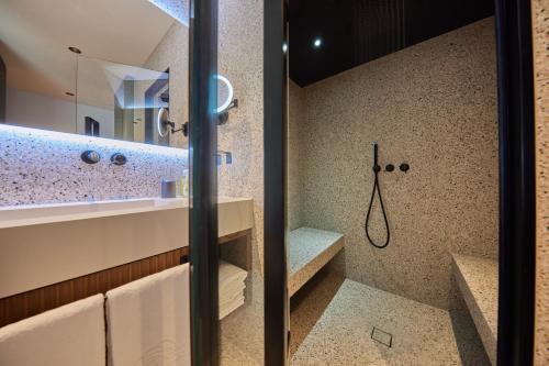 a bathroom with a walk in shower and a sink at Hotel Baia Verde in Malcesine