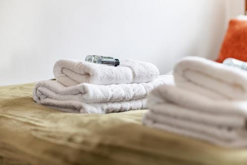 una pila de toallas sentadas encima de una cama en Comfortable 1BR flat in Canary Wharf en Londres
