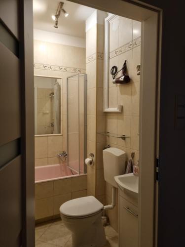 La salle de bains est pourvue de toilettes, d'un lavabo et d'une baignoire. dans l'établissement Apartament 51, à Gdynia