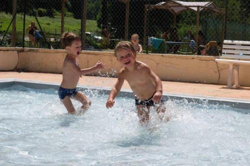 two young boys playing in a swimming pool at Appart 7 Laux - Balcon Sud in Les Adrets