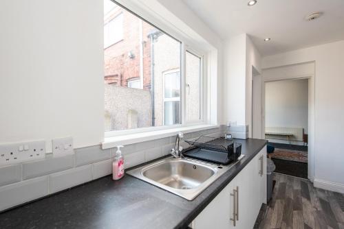 uma cozinha com um lavatório e uma janela em Rose Street em Monkwearmouth