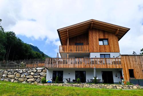 a house with a wooden roof and a deck at MottHof in Lermoos