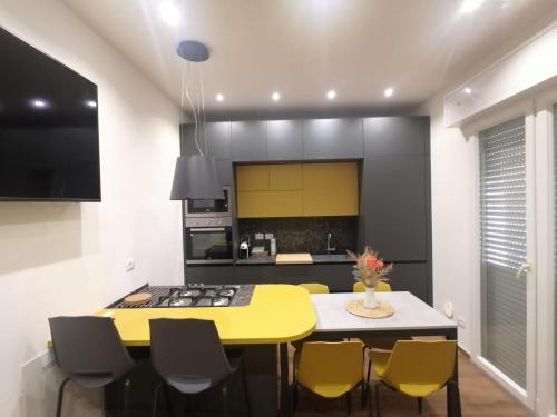 uma cozinha com uma mesa amarela e cadeiras amarelas em 0541 Guest House Rimini em Rimini