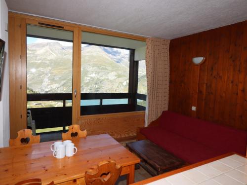 un salon avec un canapé, une table et une fenêtre dans l'établissement Studio confortable · Proche pistes · Balcon - FR-1-502-427, à Tignes