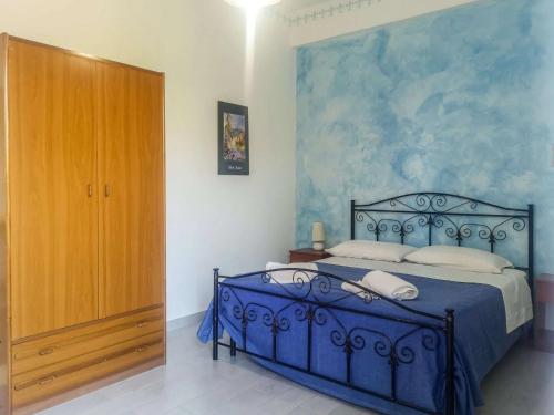 a bedroom with a blue bed and a wooden cabinet at Camping Almoetia in Calatabiano