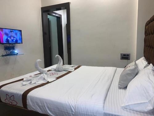 a bedroom with a bed with swans on it at The JK Hotel Nr Railway Station in Nagpur
