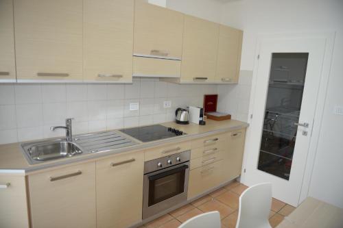 a kitchen with a sink and a stove top oven at Appartamento Laura in Merano