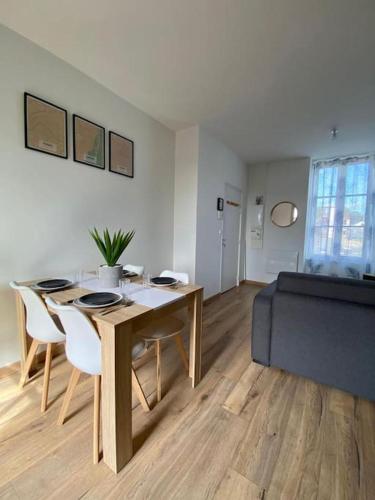 a living room with a table and chairs and a couch at LOFT Jardin et Spa in Bressuire